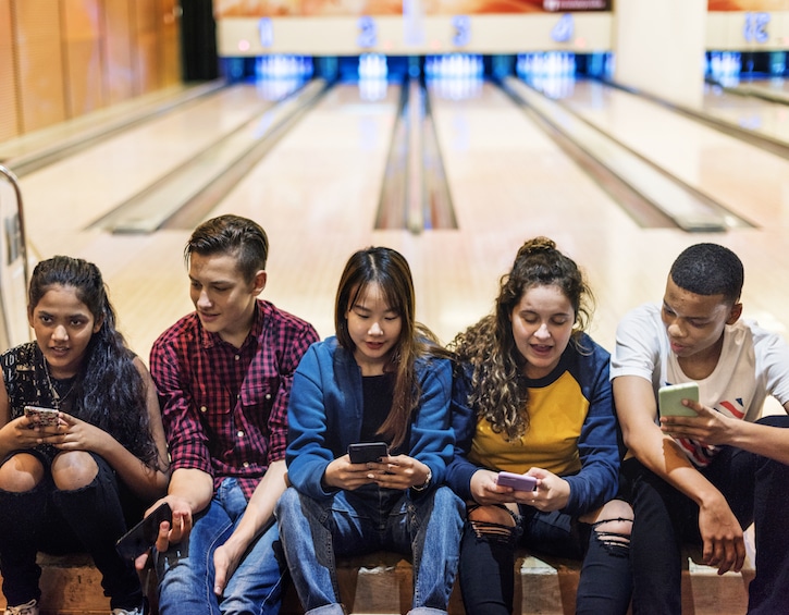 Kids on phones at bowling alley