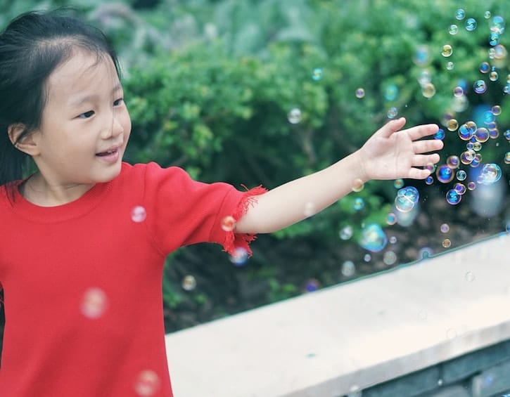 young girl playing with bubbles
