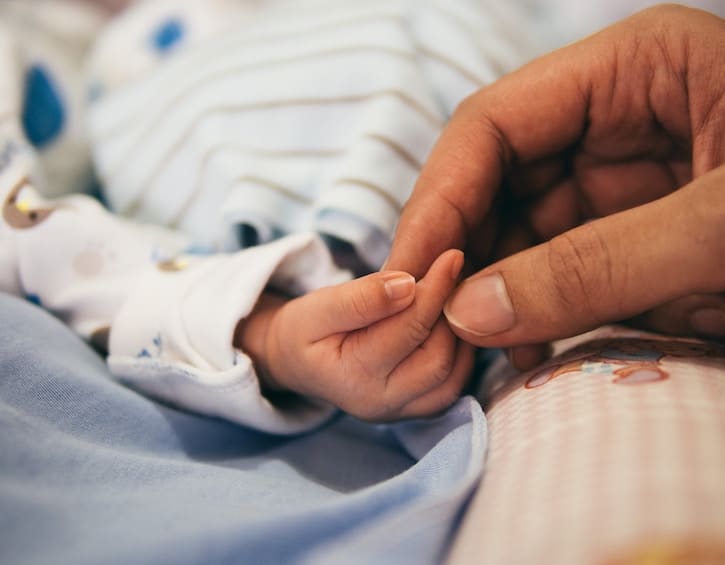 parent holding baby hands