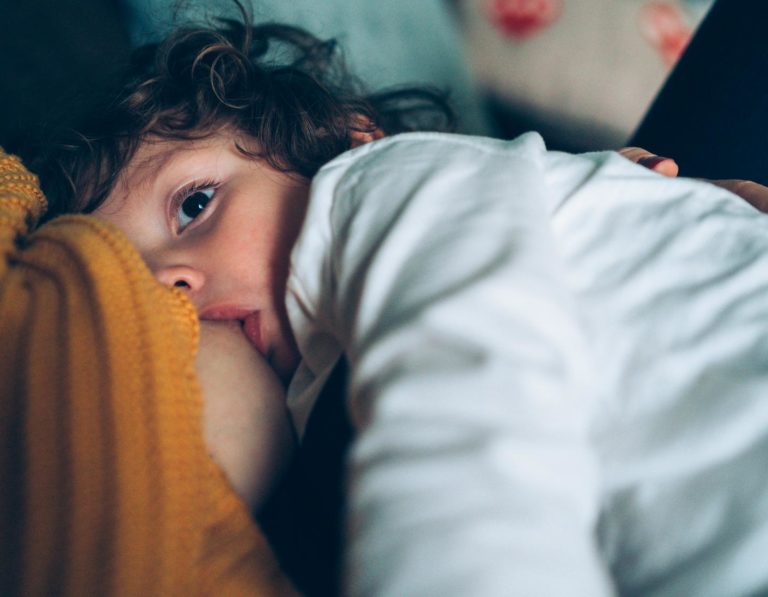 Toddler relaxing and breastfeeding