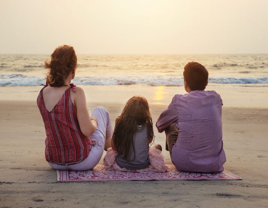 family looking at the sunset on a beach