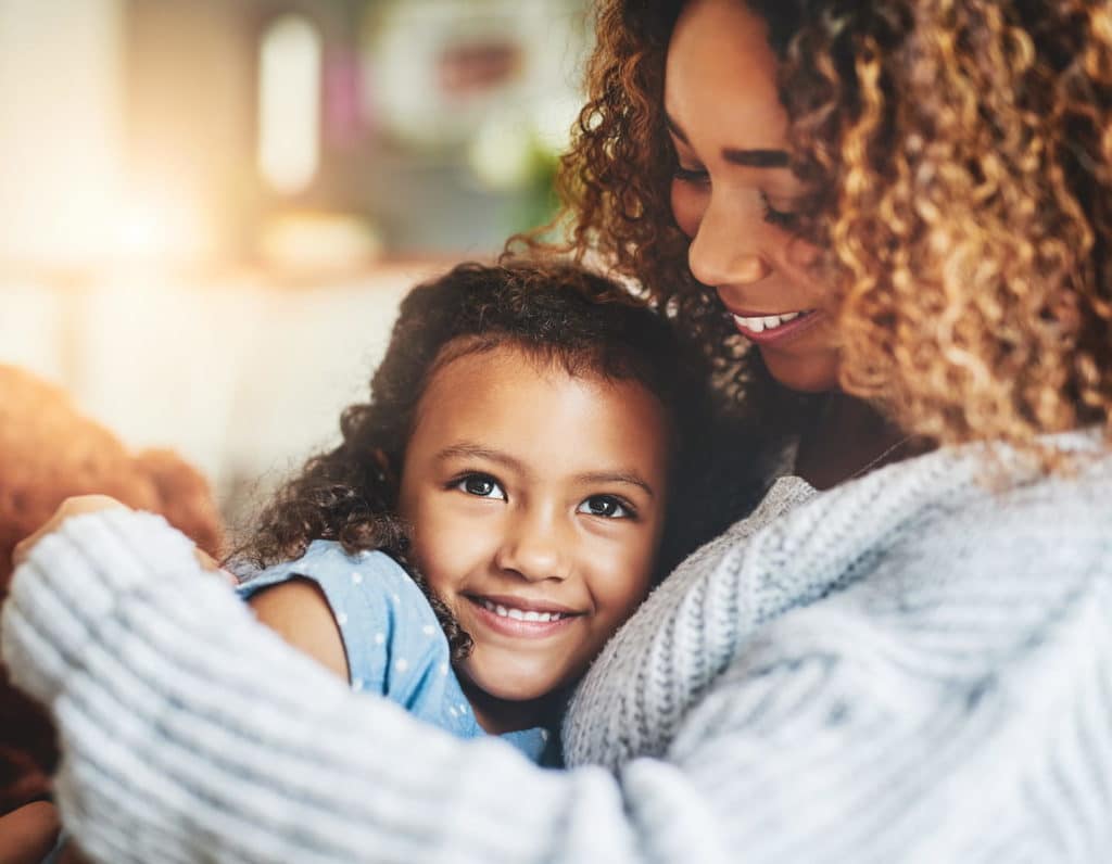 Mama and daughter have a cuddle on the sofa, child emotions