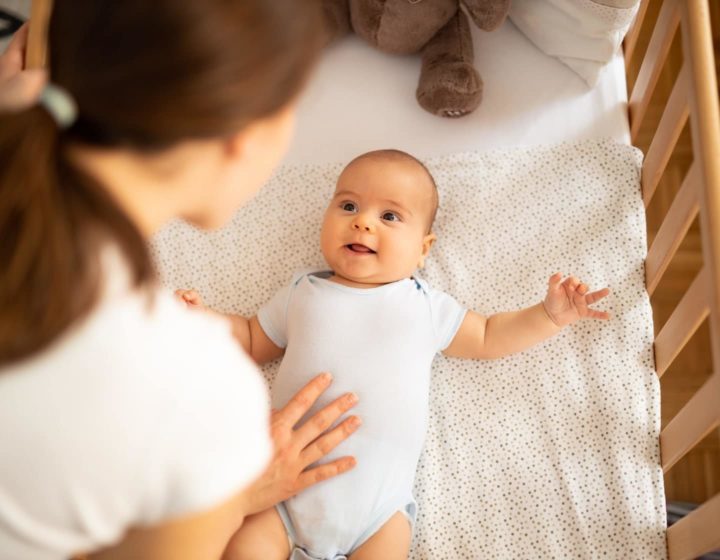 Mother putting baby to bed with sleep coach in Hong Kong