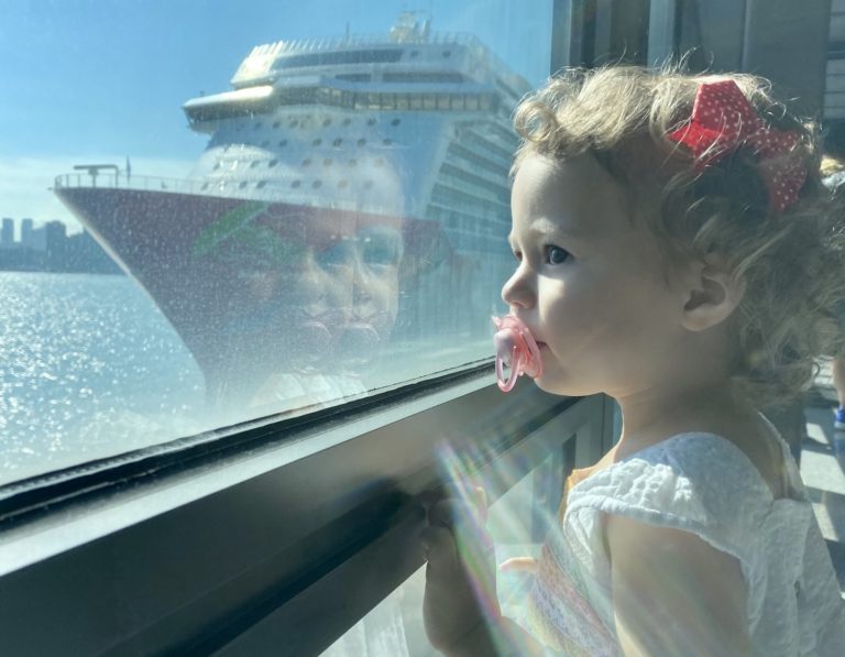 Cruise in Hong Kong, toddler looks out at the Genting Dream by Dream Cruises