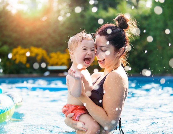 Kids swimwear, Baby boy splashing and having fun with mum in the pool.