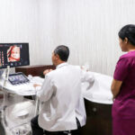 gynaecologist and a nurse performing an ultrasound on a pregnant woman in hong kong at obstetrician clinic