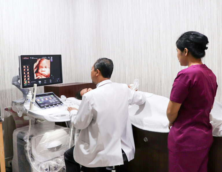 gynaecologist and a nurse performing an ultrasound on a pregnant woman in hong kong at obstetrician clinic