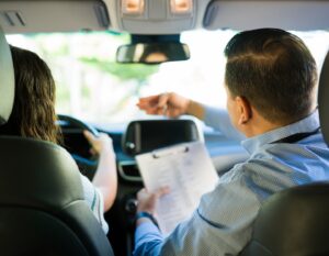 a Hong Kong driving instructor teaches a student to drive at a Hong Kong driving school