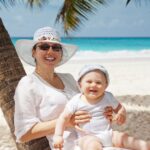 cute baby with mum on a tropical beach fighting jet lag after travel