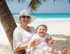 cute baby with mum on a tropical beach fighting jet lag after travel