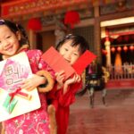 Two girls wearing cheongsam make a New Year’s visit.