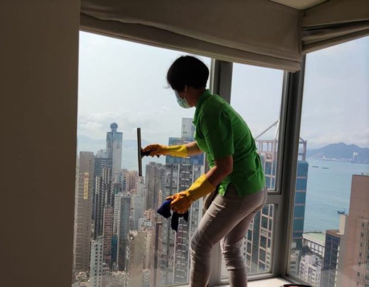 House cleaning service Merry Maid helper cleaning the windows