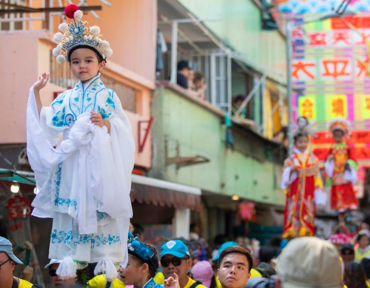 Cheung Chau Bun Festival Piu Sik Parade featuring child standing on wooden panels roaming around the streets of Cheung Chau