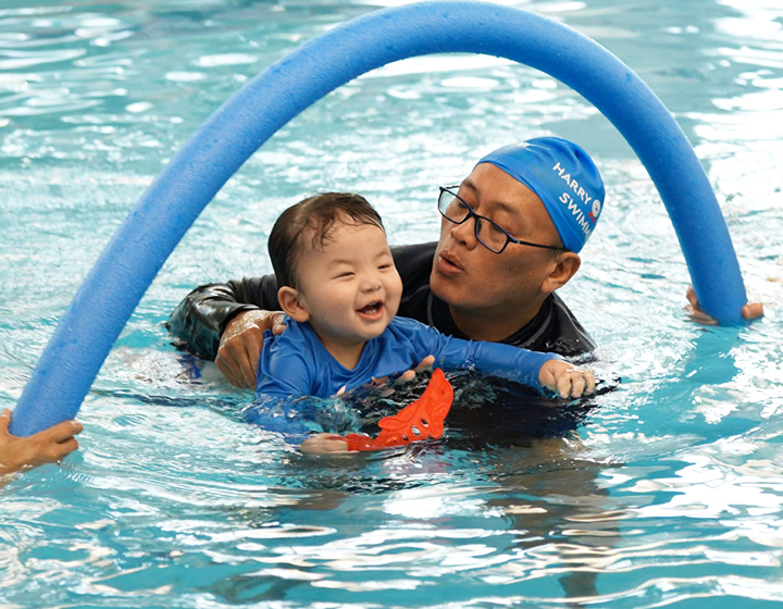 toddler and coach in the pool during a swimming lesson at harry wright swim school hong kong