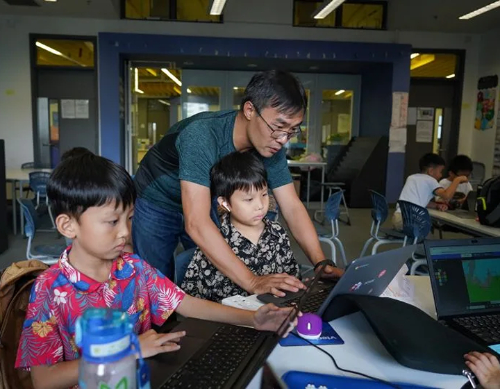 teacher showing student how to code at esf explore coding class hong kong