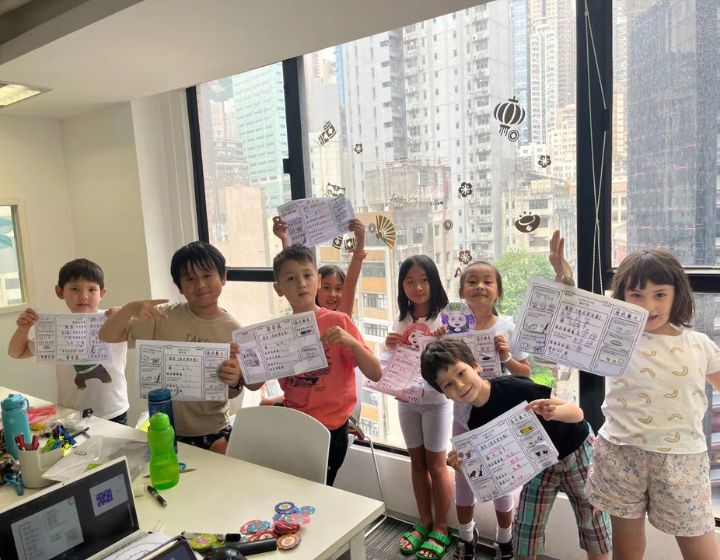 Mandarin Time School Inspiring confident Mandarin learners through expert teaching and immersive programmes class of kids holding up Mandarin assignments