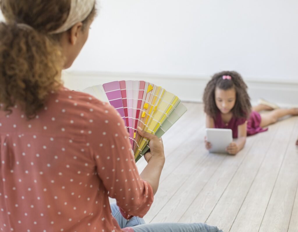 an interior designer in Hong Kong chooses paint colours while daughter lies on the floor