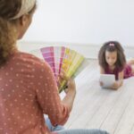 an interior designer in Hong Kong chooses paint colours while daughter lies on the floor