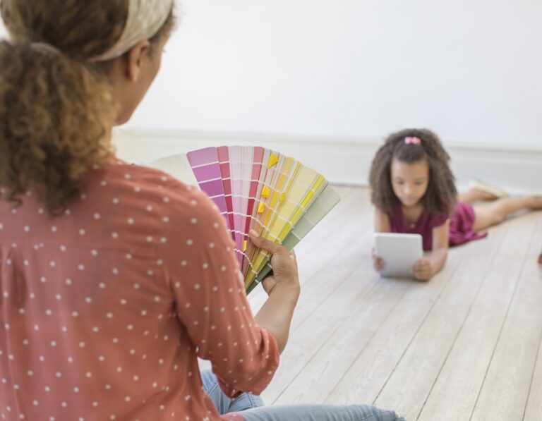 an interior designer in Hong Kong chooses paint colours while daughter lies on the floor