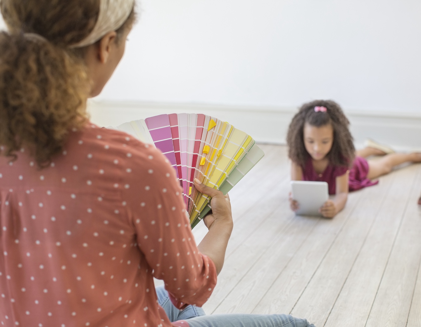 an interior designer in Hong Kong chooses paint colours while daughter lies on the floor