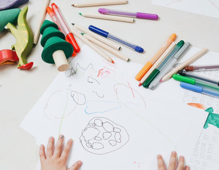 stationery and child's drawing with a bunch of back to school supplies