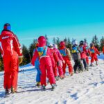 a group of ski students with an instructor at an international camp