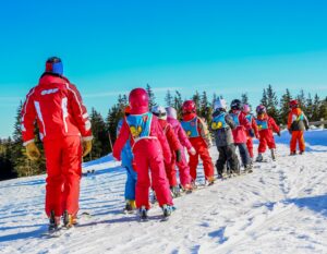 a group of ski students with an instructor at an international camp