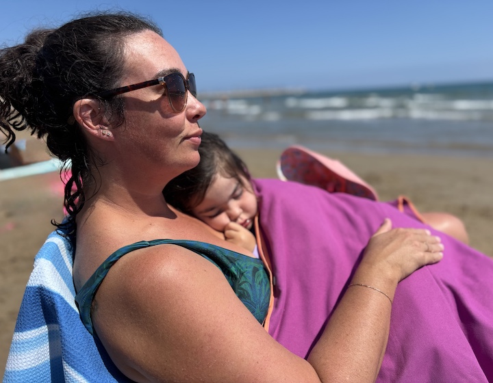 mum with daughter napping on the beach in Spain