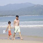 father and son walk along the beach in Hong Kong