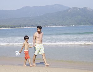 father and son walk along the beach in Hong Kong