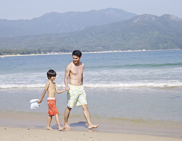 father and son walk along the beach in Hong Kong