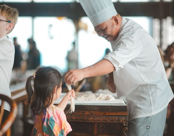 Hutong girl watching noodle pulling at dim sum brunch