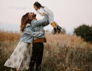 Photo of a family, two parents and a child, taken outdoors by a family photographer