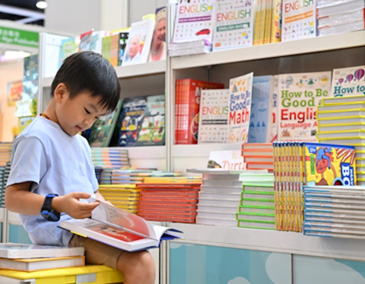 a boy reads books at a stall at the Hong Kong Book Fair in 2026