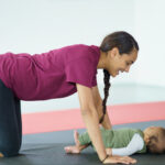 new mother doing a postnatal fitness class with her baby, mum and bubs workout class, postnatal Pilates in Hong Kong
