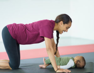 new mother doing a postnatal fitness class with her baby, mum and bubs workout class, postnatal Pilates in Hong Kong