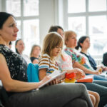 parents and students in a classroom learning about the school at an open day