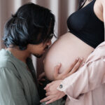 man kissing pregnant stomach; what fathers can do to support pregnancy and fertility success