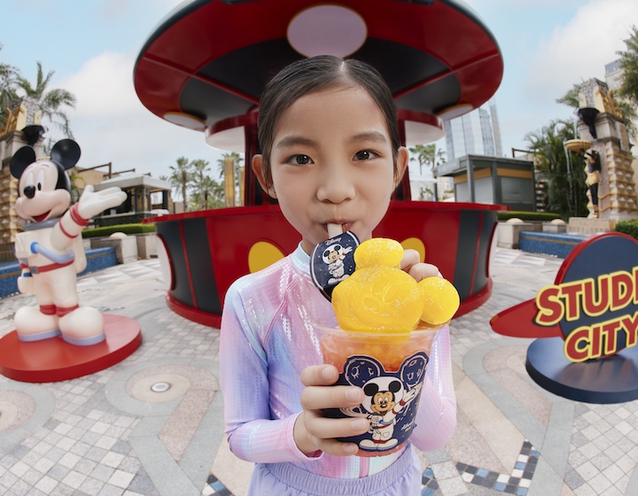 a girl sips a cool Mickey Mouse drink at Studio City Macau in summer