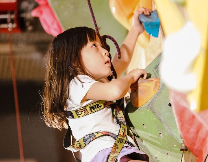 a girl rock climbing at an indoor bouldering centre in Hong Kong