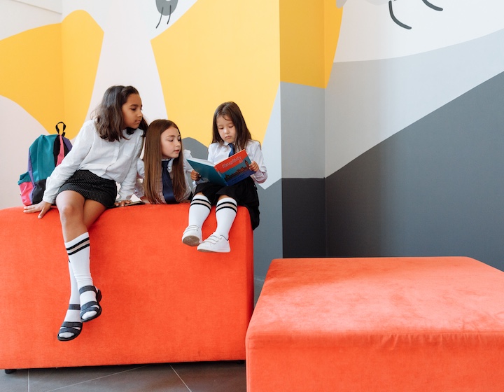three girls reading at an affordable international primary school in Hong Kong