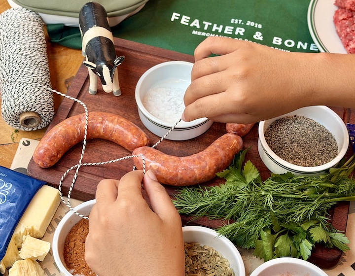 child's hands making sausages at feather and bone