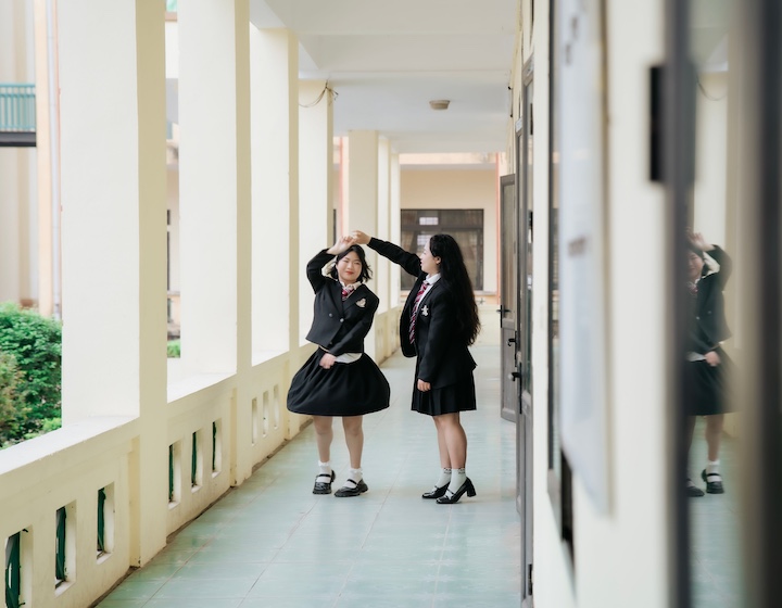 two Hong Kong high school students dance in the corridor after getting their ib results
