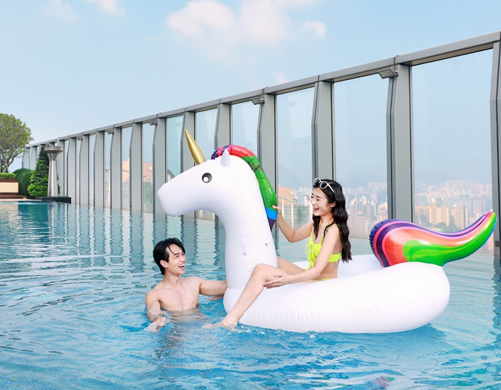 Couple relaxing beside the rooftop swimming pool at W Hong Kong