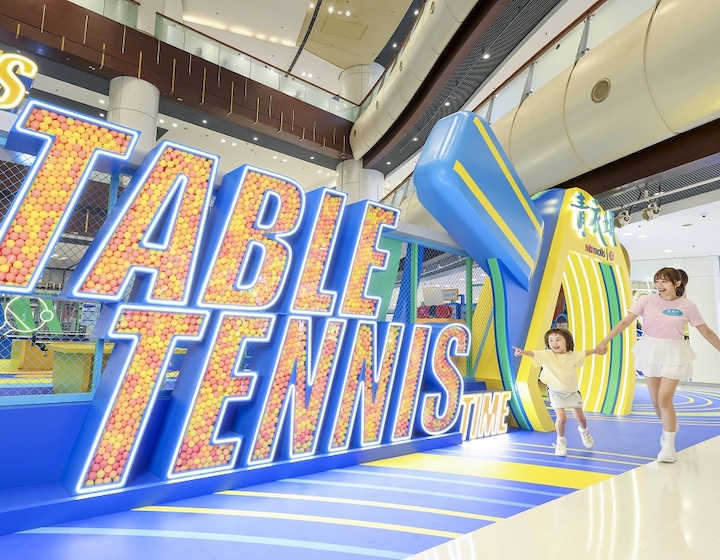 mother and daughter run towards a giant table tennis sign in maritime square Hong Kong
