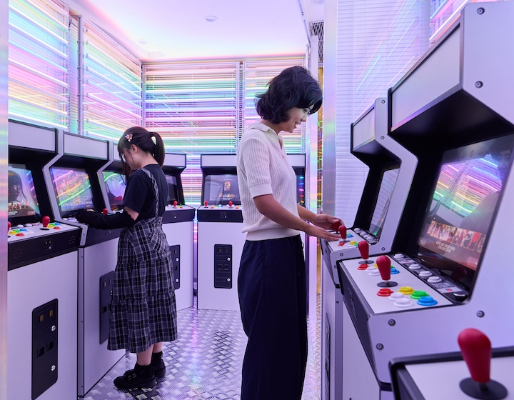 mother and daughter play old arcade games at the power of play exhibit in Hong Kong