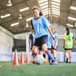 a teenage girls practices ball skills at a kids sports class
