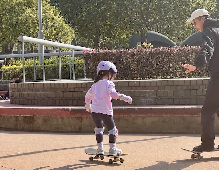 a young girl learns to ride a skateboard in Hong Kong