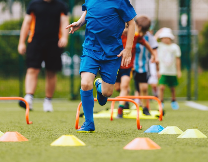 a boy runs through obstacles at kids sports class