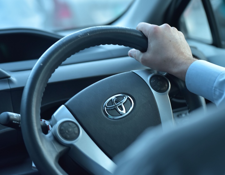 close up of a mans hand on a car steering wheel during a Hong Kong driving lesson